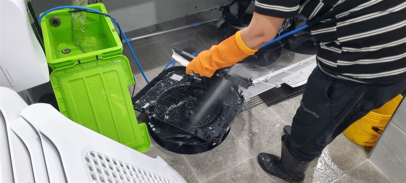 송풍팬을 고압 세척기로 씻어내는 모습