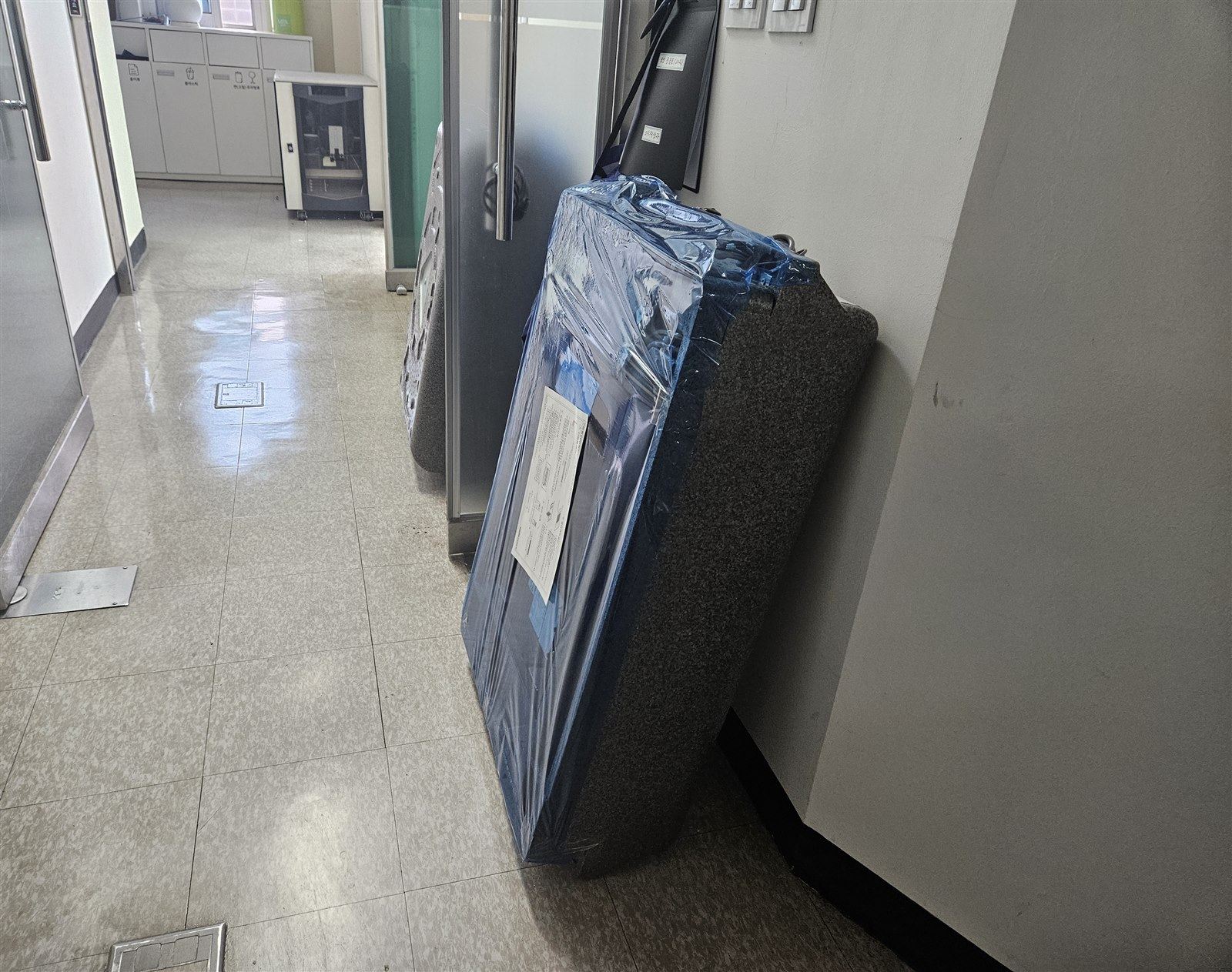 포장된 새 팬코일유닛을 복도로 반입한 모습
