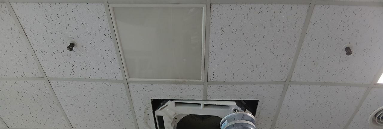 세척 용기를 달고 세척 중인 체육문화센터 천장형 냉난방기
