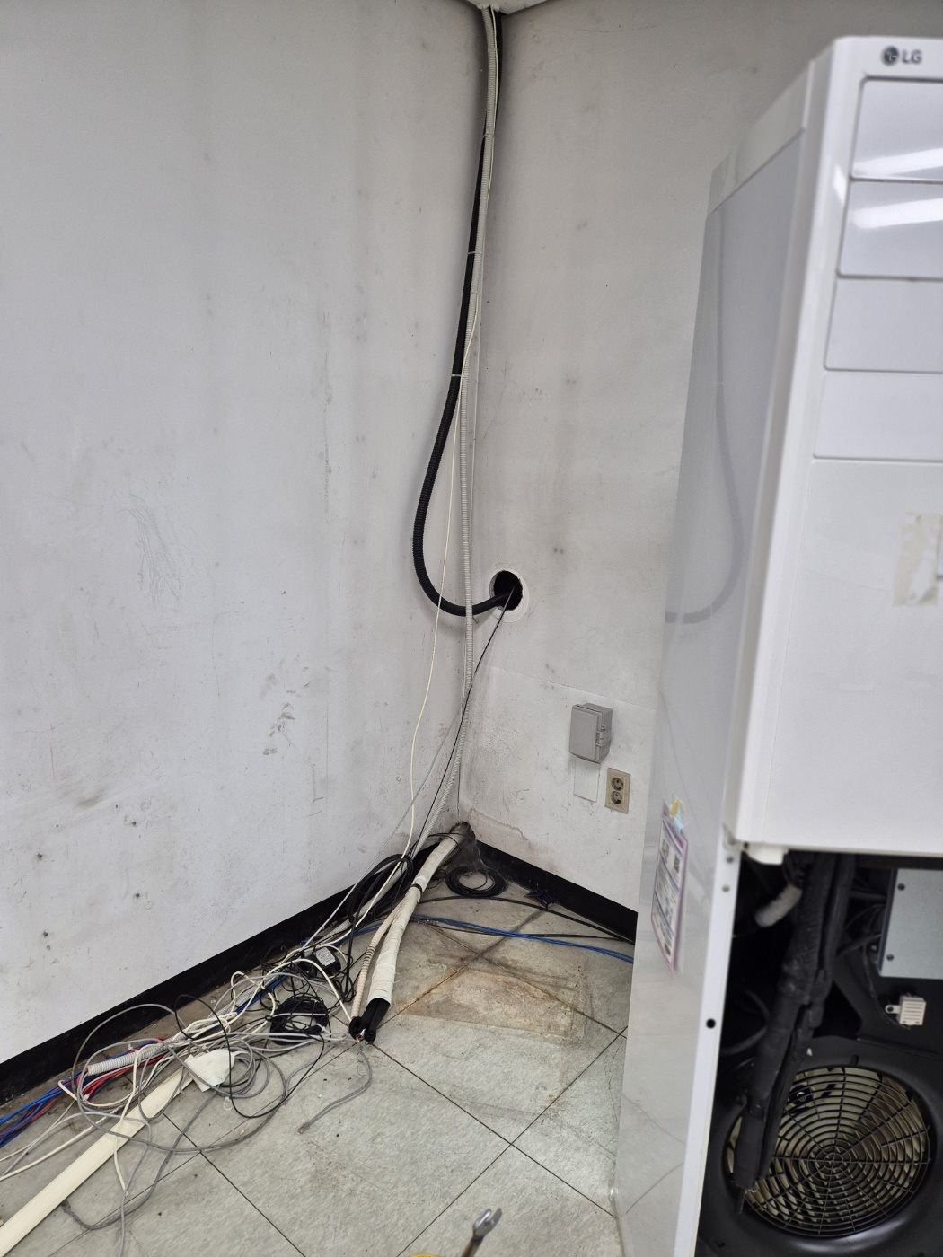 벽에서 떼어 낸 실내기와 끝을 막아 둔 배관